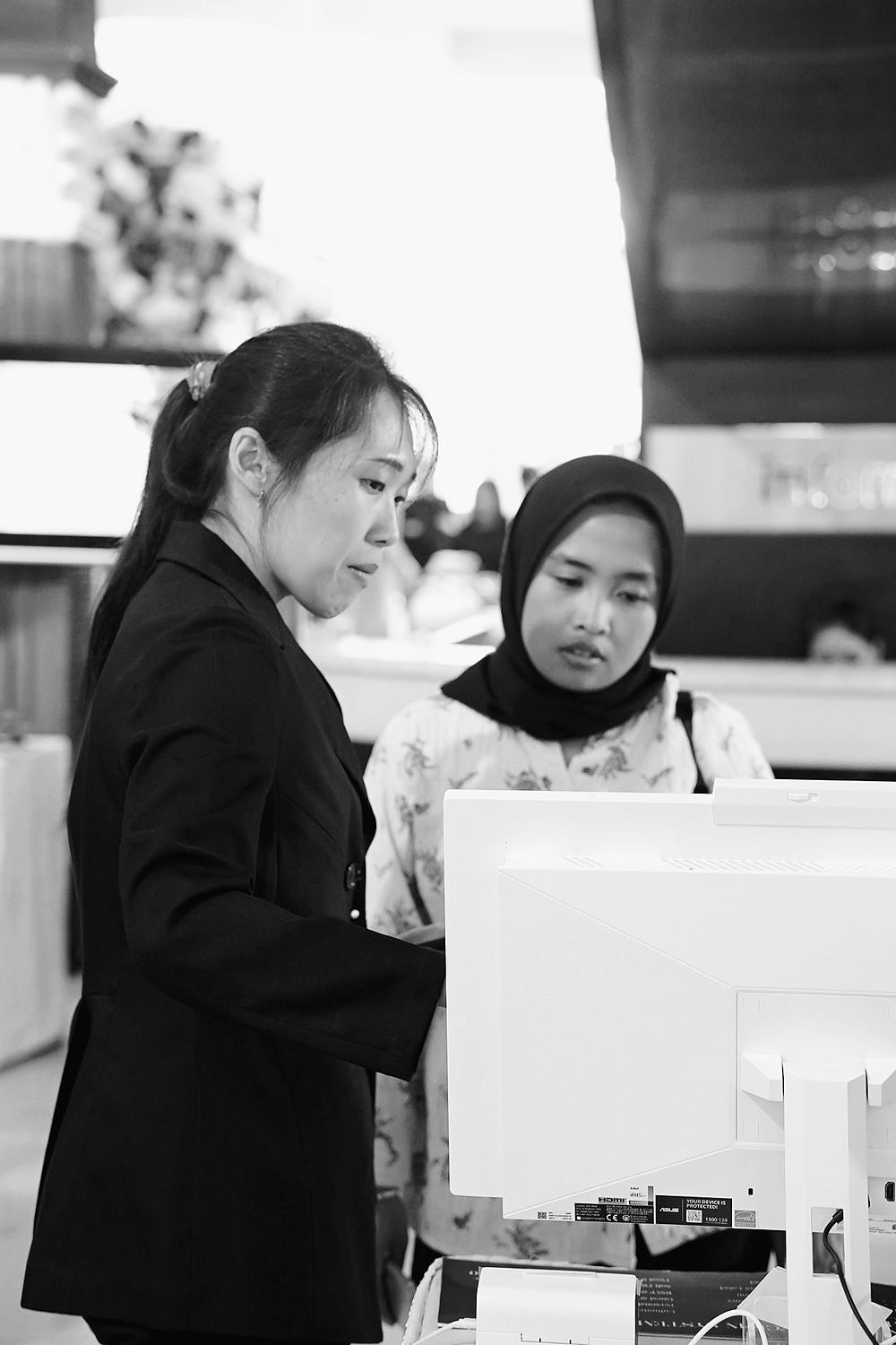 An Invitamu host helping a guest at the check-in desk